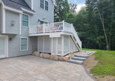 Concrete floor outside house with natural rocs and concrete steps - hardscapes brookline nh