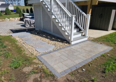 House with concrete floor before exterior staircase - hardscapes candia nh